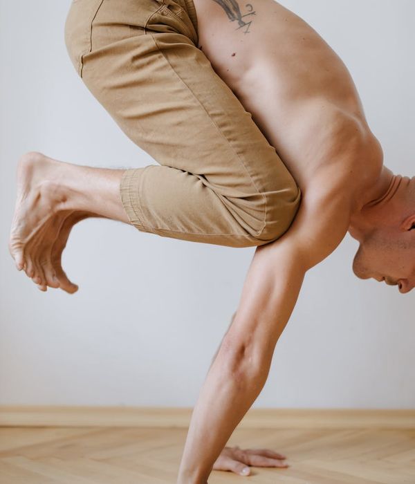 Man holding a difficult balance pose, showing concentration and body control.