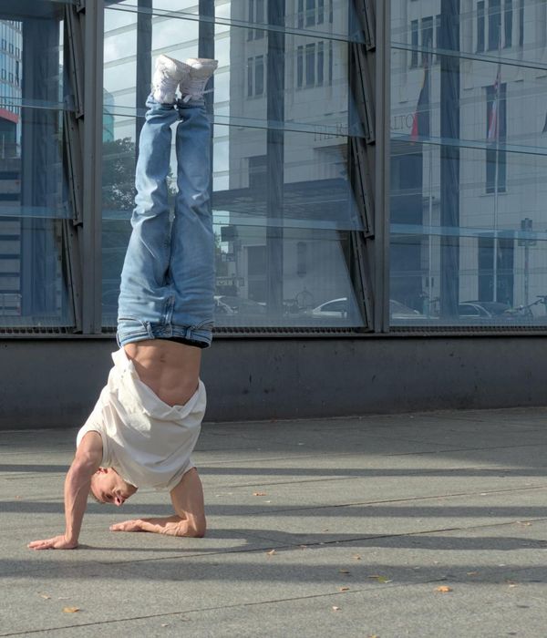 Man performing a strength-building core exercise in a minimalist dark room.